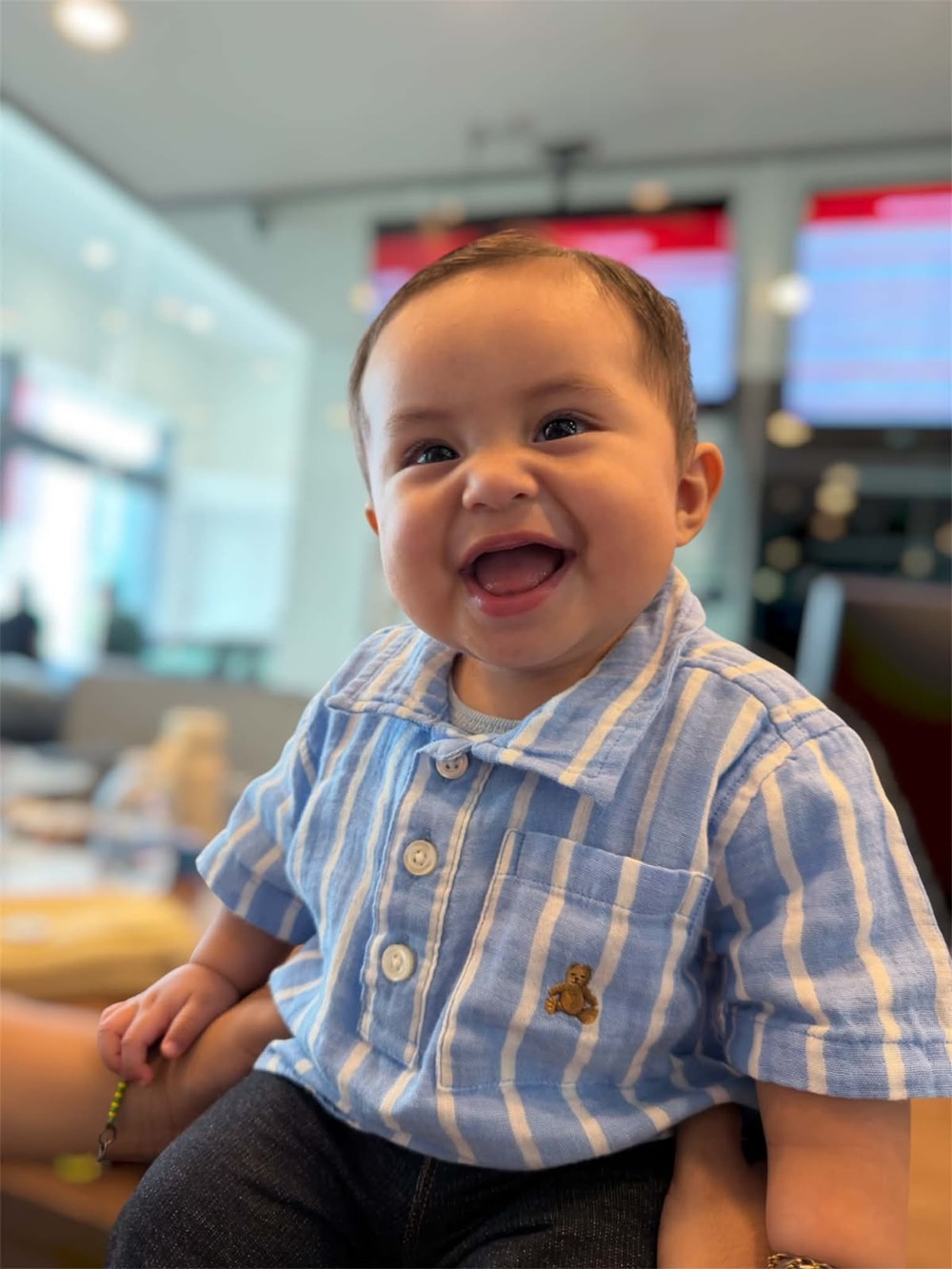 Damián sonriendo con su camisa de rayas